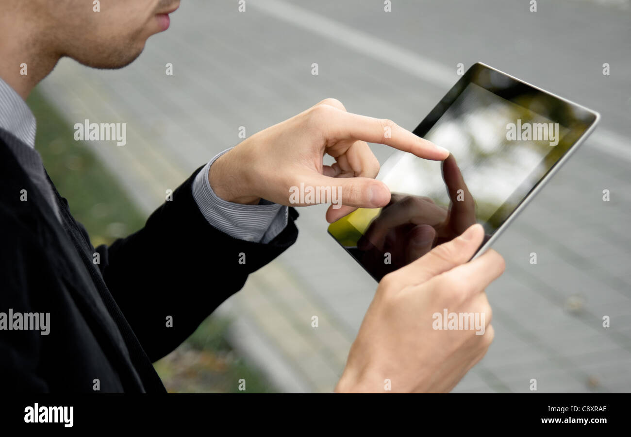 Mancino businessman holding e toccante sul digitale tablet pc al parco. Foto Stock