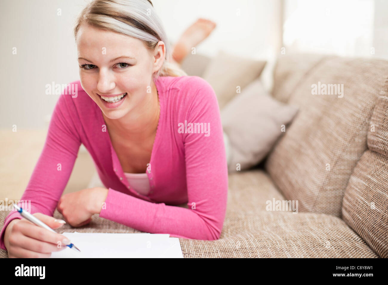 Ritratto di giovane donna in casa a lavorare sul personal finance Foto Stock