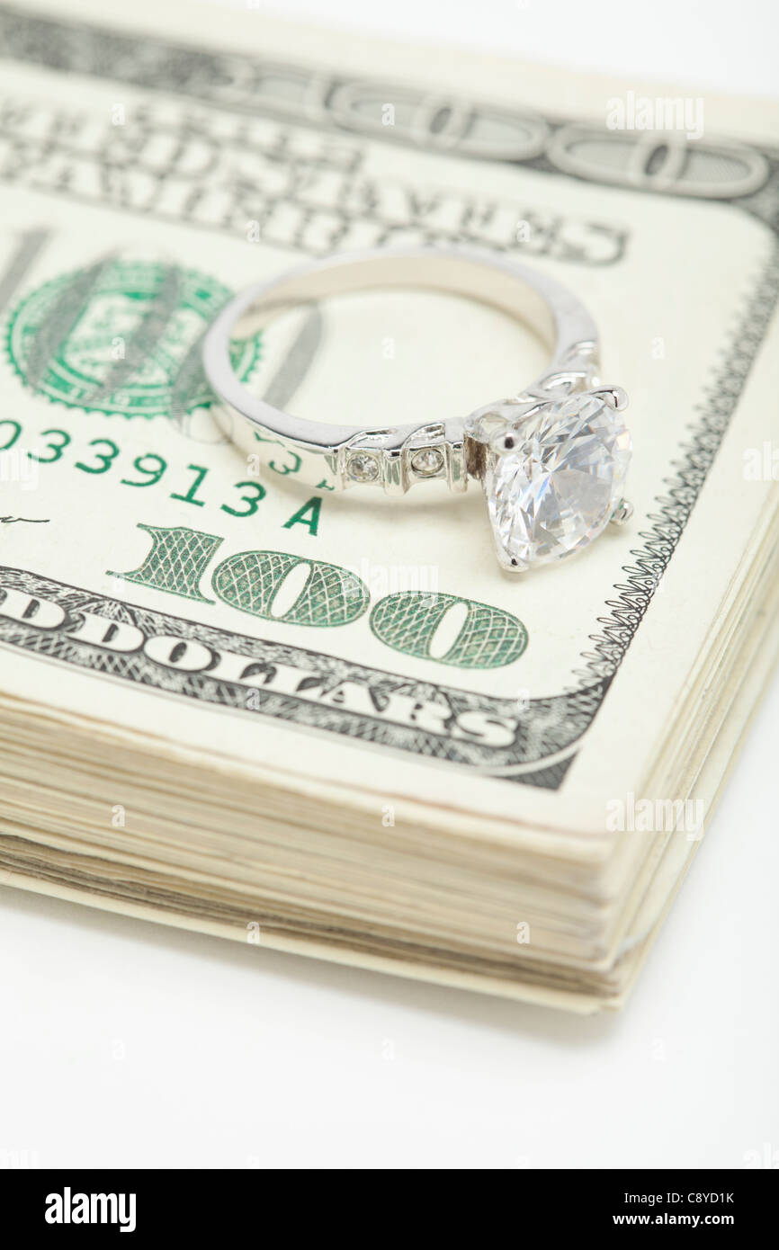 Anello in argento sul mazzetto di banconote di dollari, studio shot Foto Stock