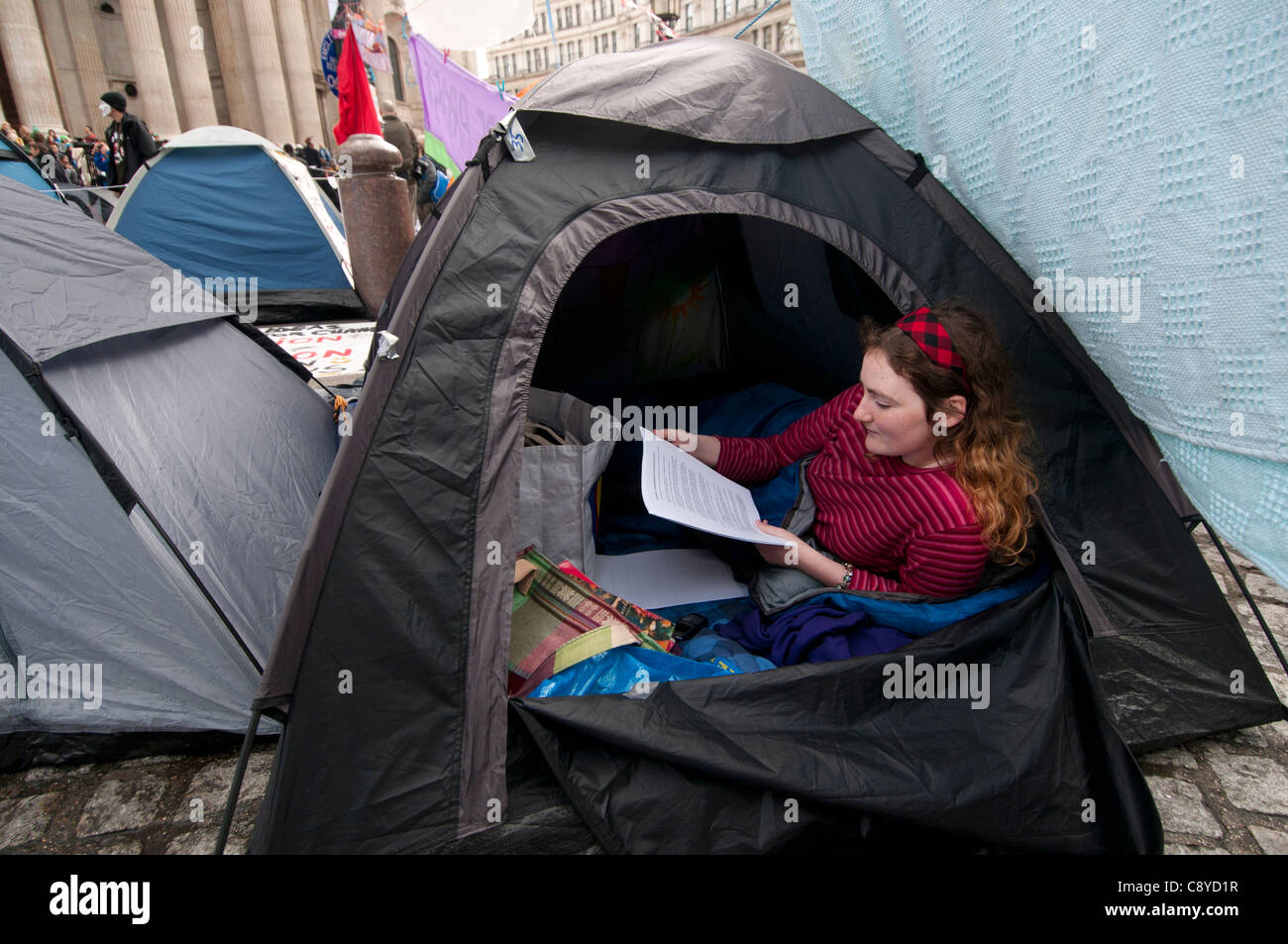 Occupare Londra a San Paolo il 1 novembre 2011. Jenny, 3° anno studente inglese lettura nella sua tenda Foto Stock