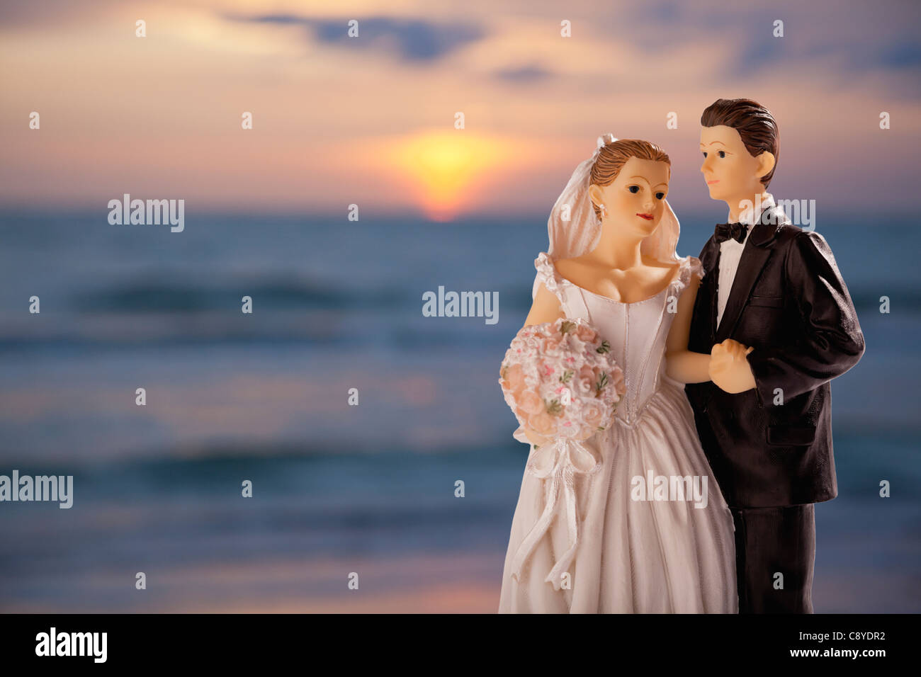 Matrimoni figurine sullo sfondo con tramonto sul mare, studio shot Foto Stock