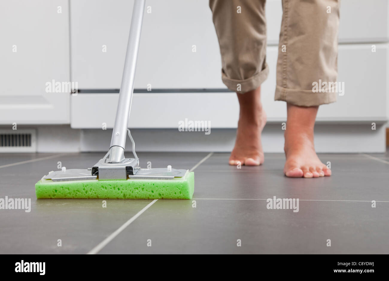 Stati Uniti d'America, Illinois, Metamora, a piedi nudi donna pulizia pavimento della cucina, sezione bassa Foto Stock