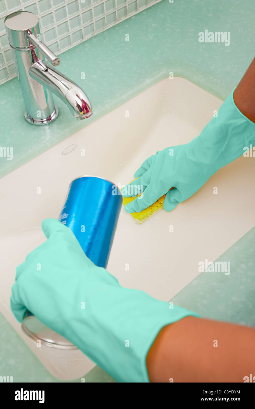 Stati Uniti d'America, Illinois, Metamora, Close-up della donna nei guanti di gomma la pulizia il lavandino del bagno Foto Stock