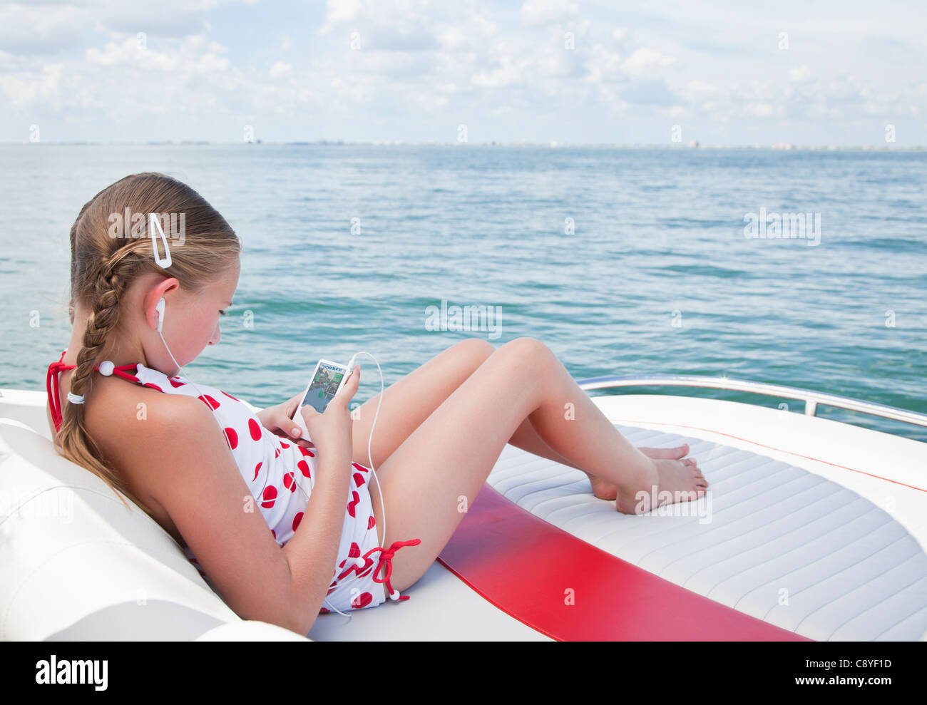 Stati Uniti d'America, Florida, San Pietroburgo, Smilling ragazza (10-11) ascoltando musica su yacht Foto Stock