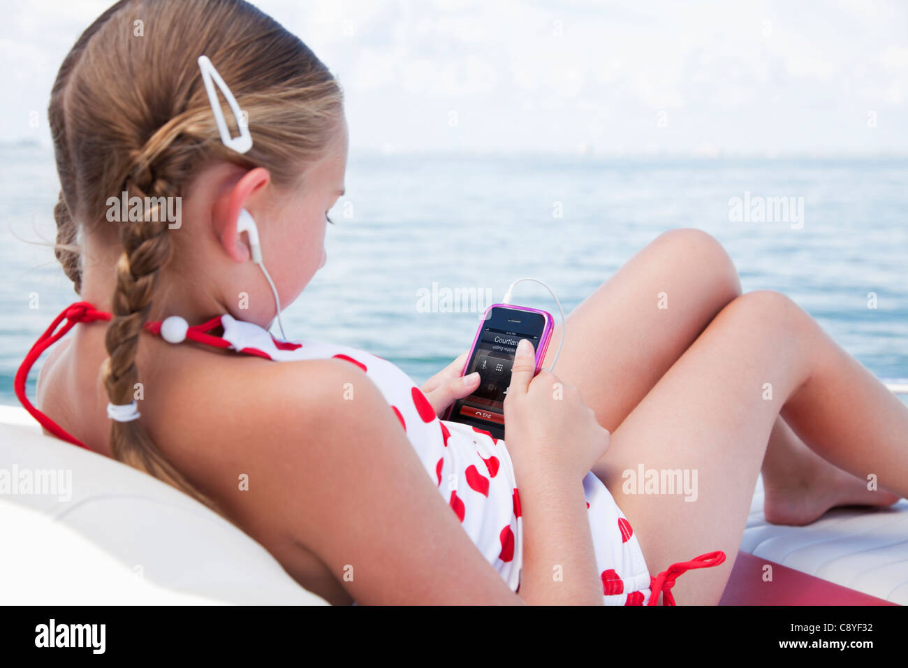 Stati Uniti d'America, Florida, San Pietroburgo, Smilling ragazza (10-11) ascoltando musica su yacht Foto Stock