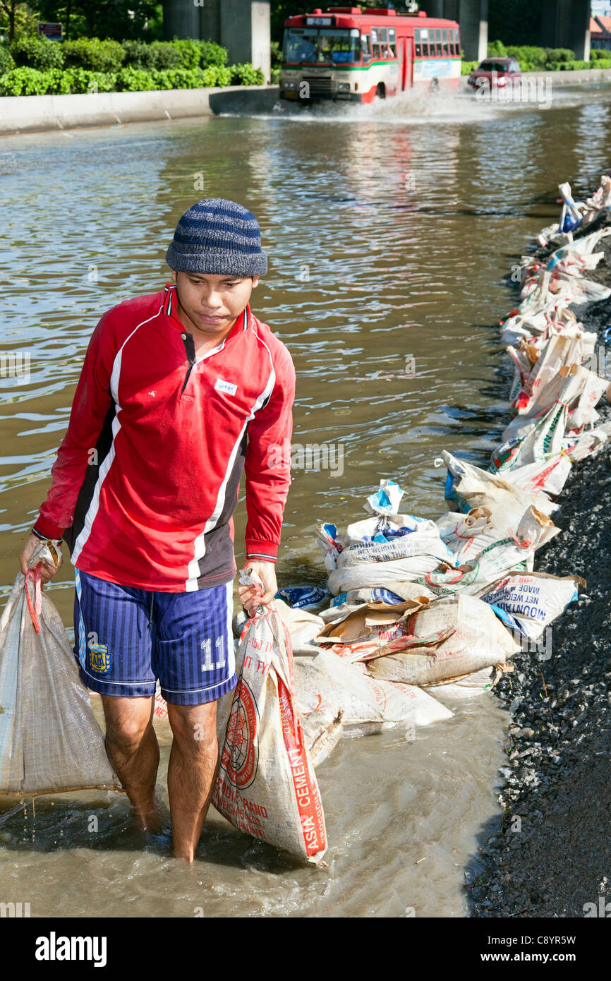 Bloccare la risalita di acque di esondazione con sacchi di sabbia su una strada vicino a Bangkok city centre, Thailandia Foto Stock