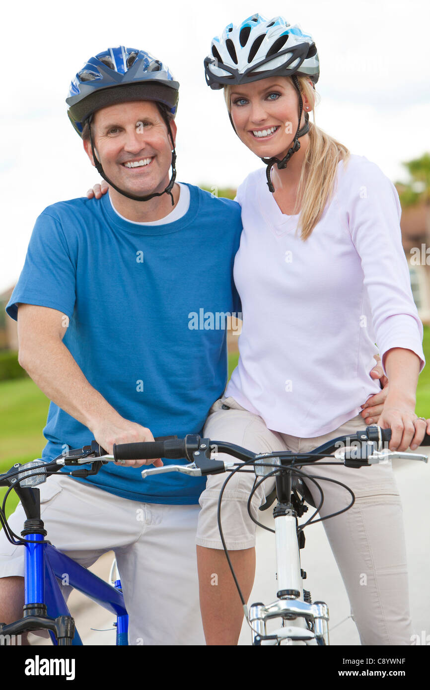 Un giovane uomo felice e donna giovane cavalcare le loro biciclette o moto Foto Stock