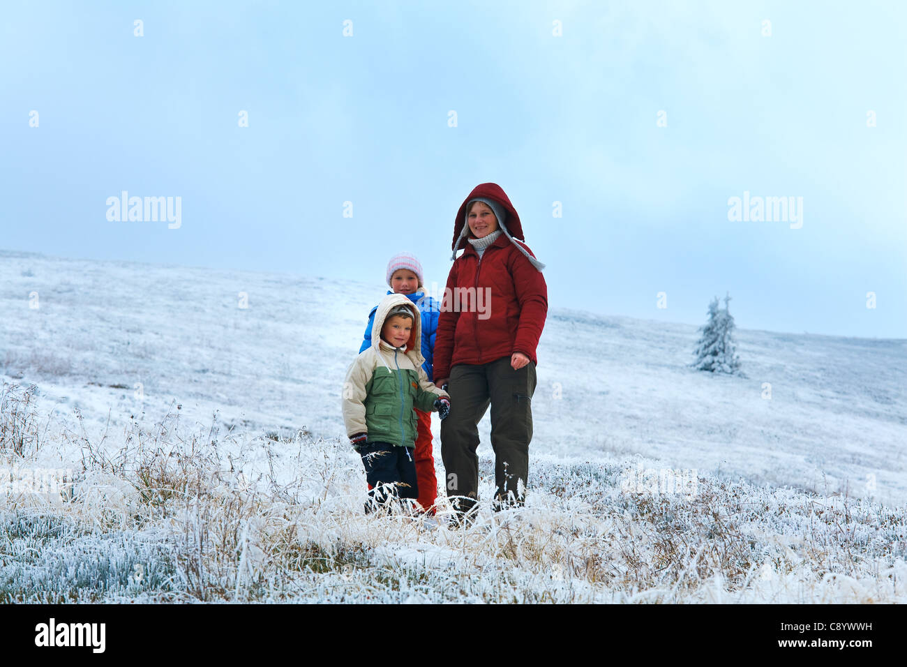 La famiglia (madre con bambini) in autunno altopiano di montagna con la prima neve invernale. Foto Stock