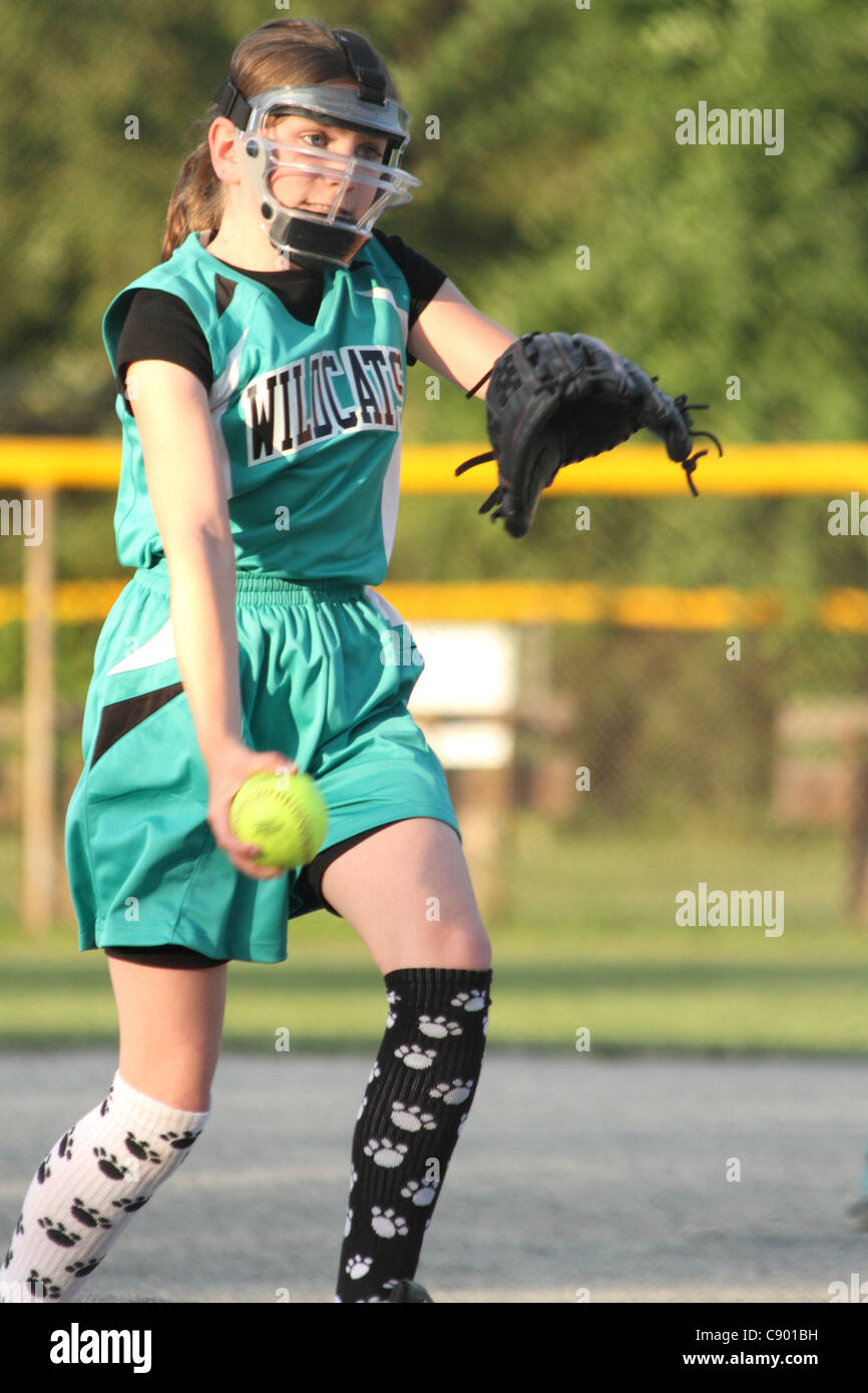 Ragazza softball pitcher al gioco con il vento fino prima del rilascio della sfera Foto Stock