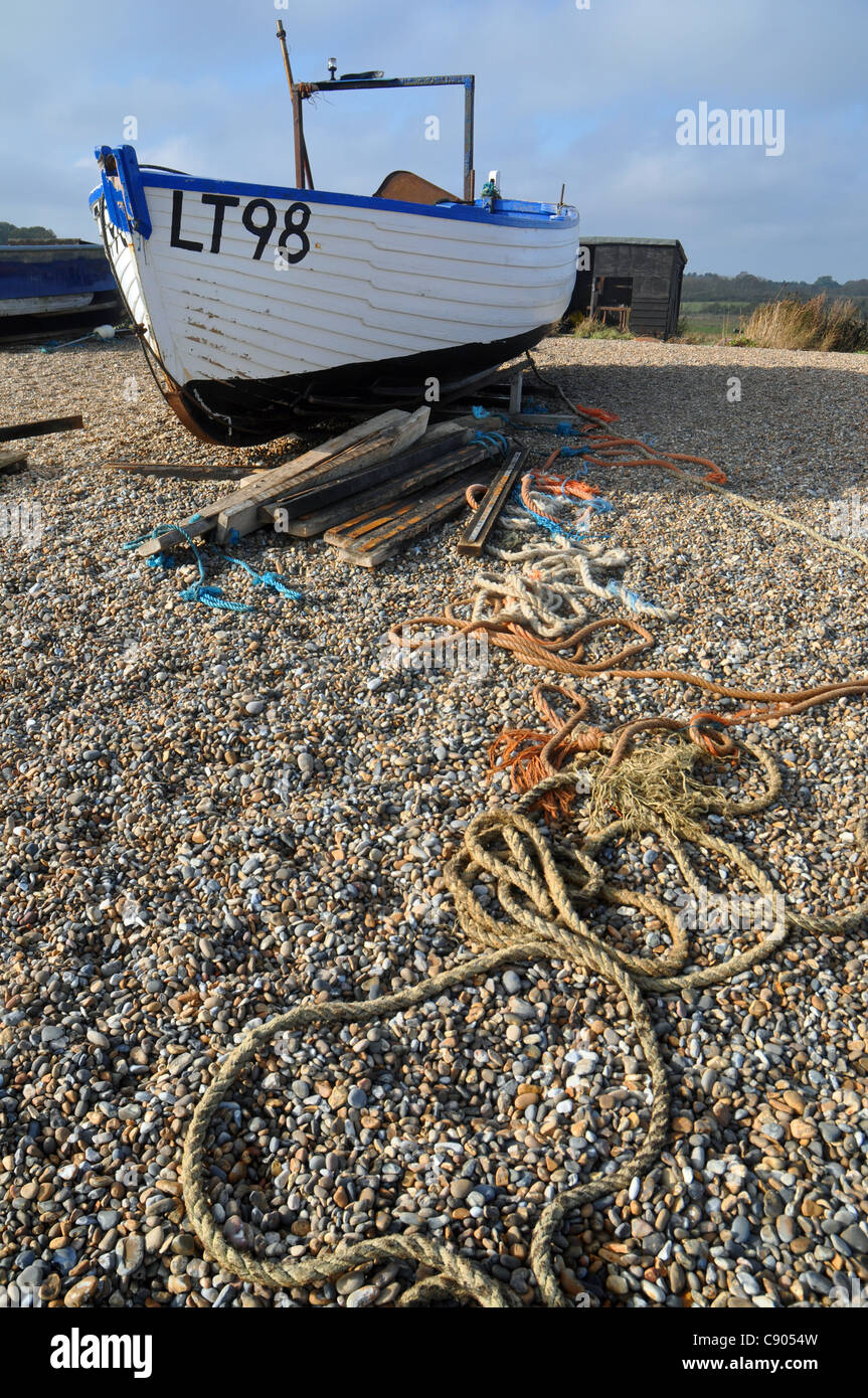 Dunwich, Suffolk, Inghilterra: barca da pesca e la bobina di corda sulla spiaggia. Foto Stock