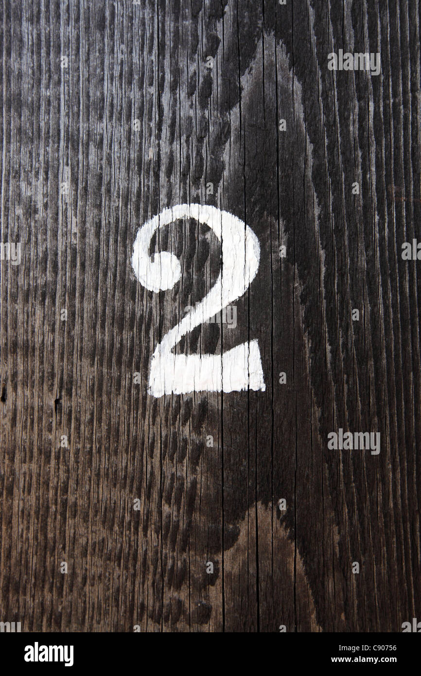 Singola cifra numero 2 due stampata su colorate porta di legno, Suffolk, Regno Unito Foto Stock
