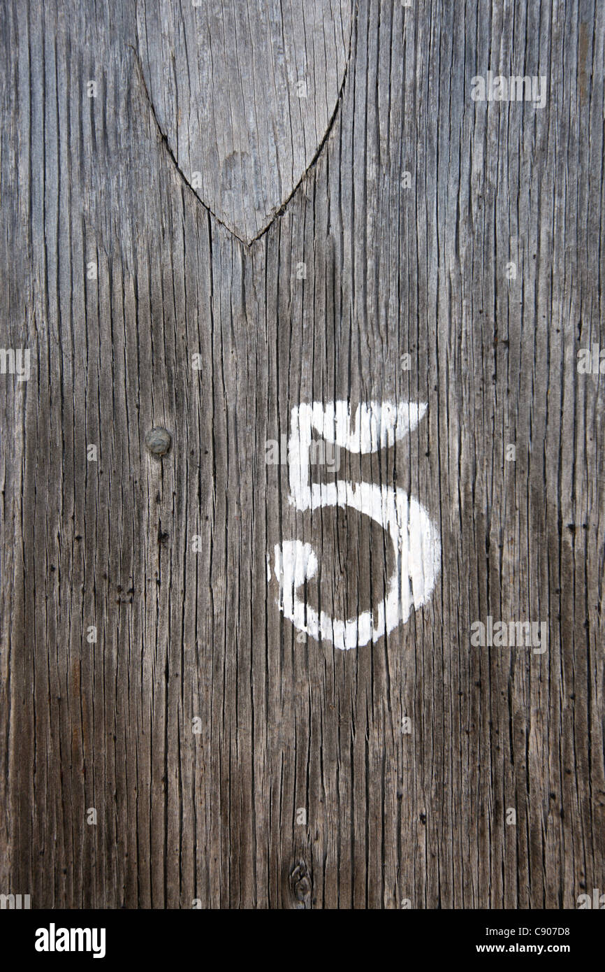 Singola cifra 5 cinque stampata su colorate porta di legno, Suffolk, Regno Unito Foto Stock