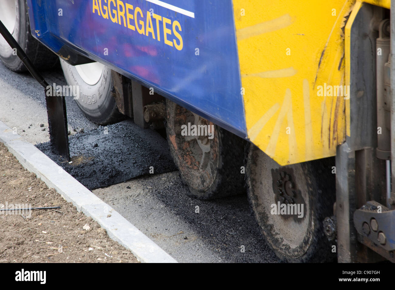 La macchina di rettifica della superficie di strada è in procinto di stabilire la tarmac attraverso una strada che di scarico è coperto con un pezzo di feltro. Foto Stock