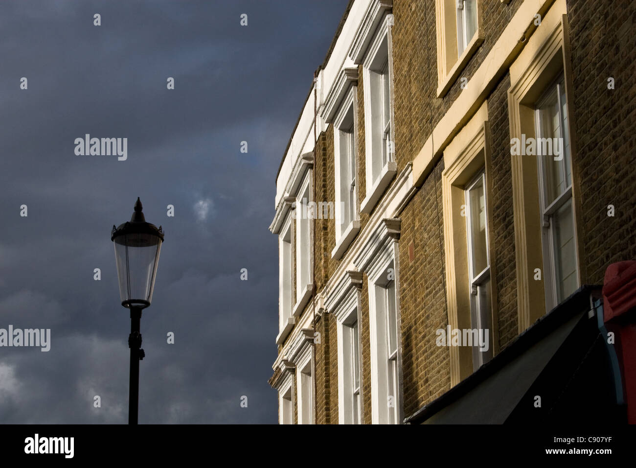 Appartamenti a schiera sopra negozi sul brillante / giorno tempestoso, Portobello Road a Notting Hill, Londra, Regno Unito Foto Stock