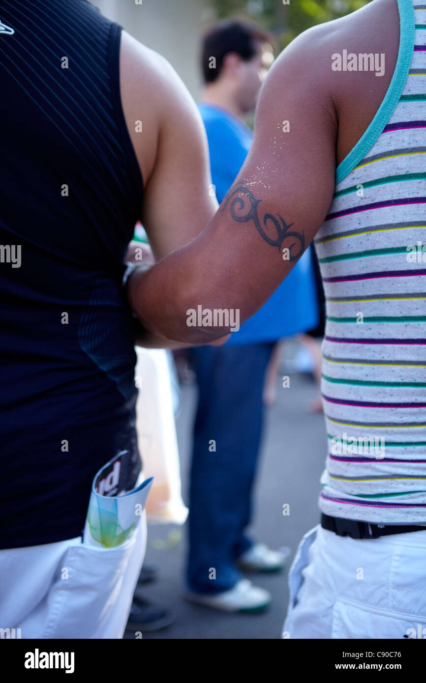 Ragazzi muscolari che si tengono per mano al tramonto, la marcia per i diritti LGBT. coppia gay nella pride gay march Foto Stock