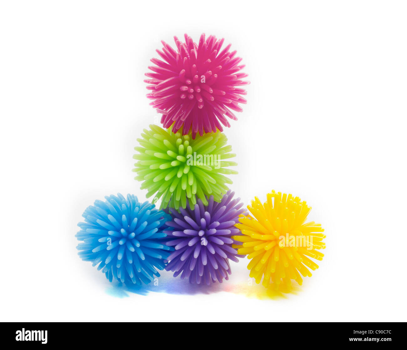 Una pila di viola, verde, blu, rosa e giallo pallina koosh palline antistress con picchi. Foto Stock