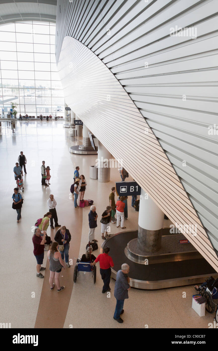 Persone in piedi in attesa per i bagagli per arrivare sul reclamo bagagli tappeto all aeroporto di San Jose in California Foto Stock