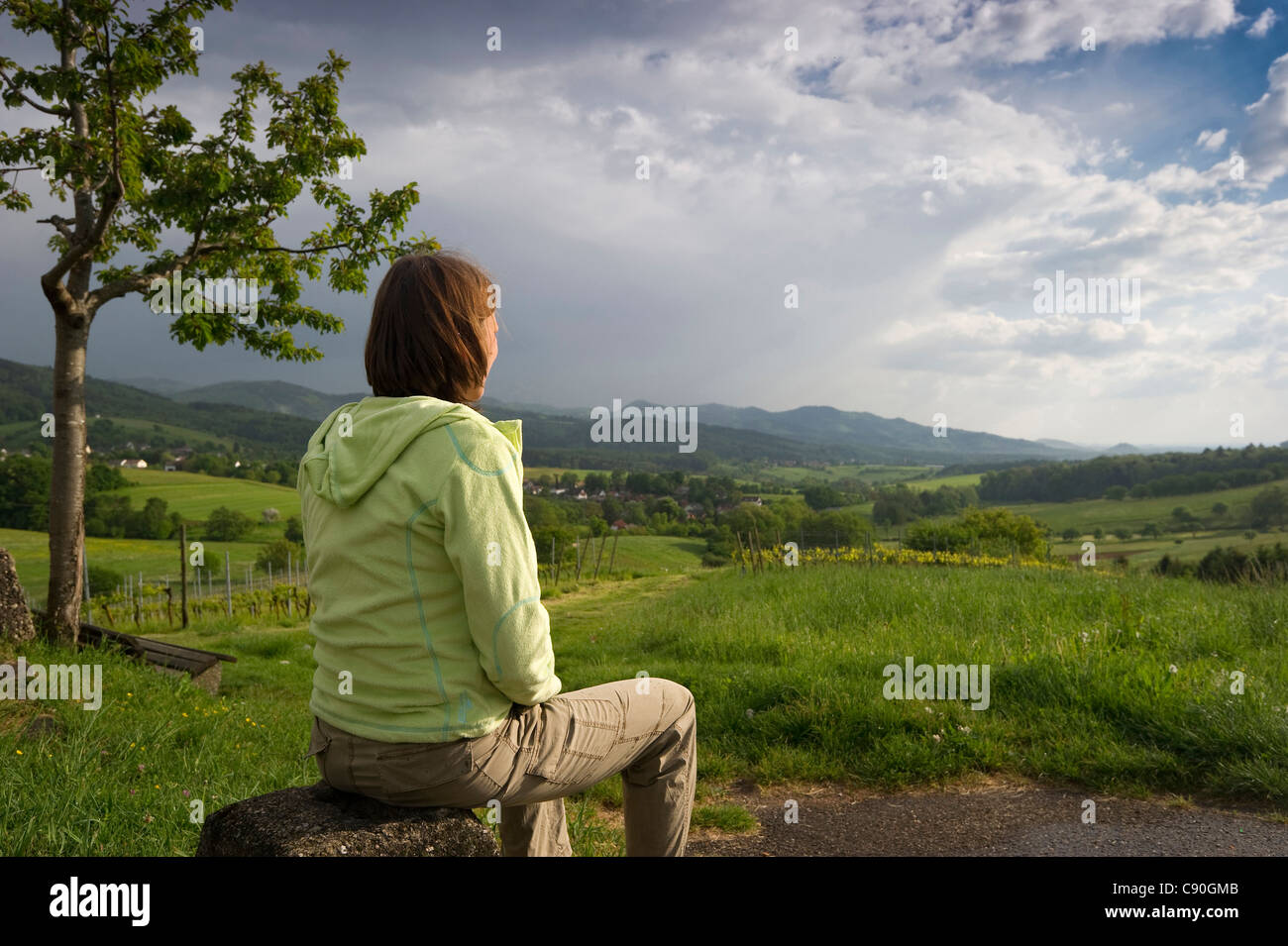 Donna seduta su una pietra, Hexental, Foresta Nera, Baden-Wuerttemberg, Germania, Europa Foto Stock