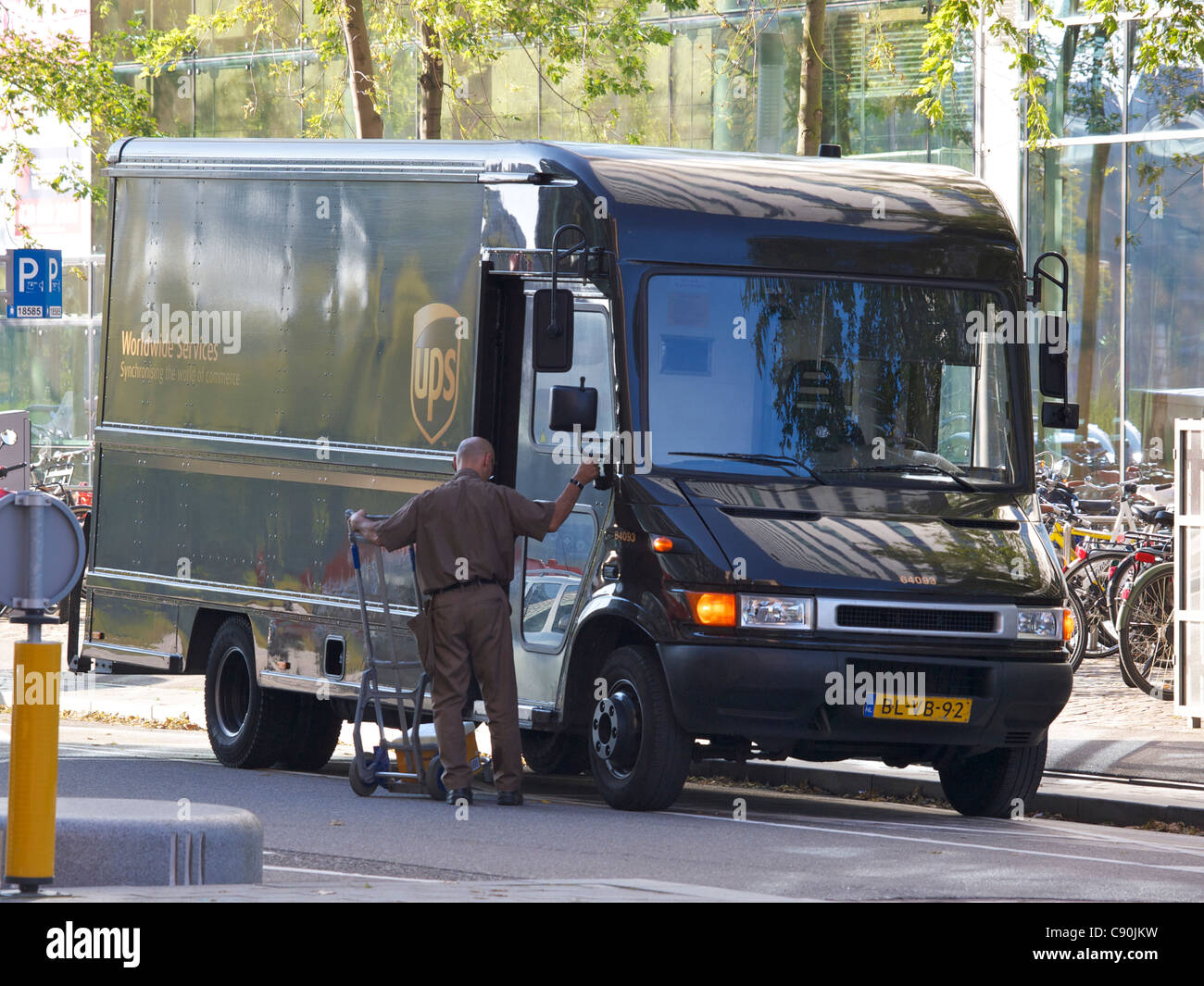 UPS l uomo con il suo camion consegnare i pacchi ad Amsterdam la Zuid-come il quartiere finanziario Foto Stock