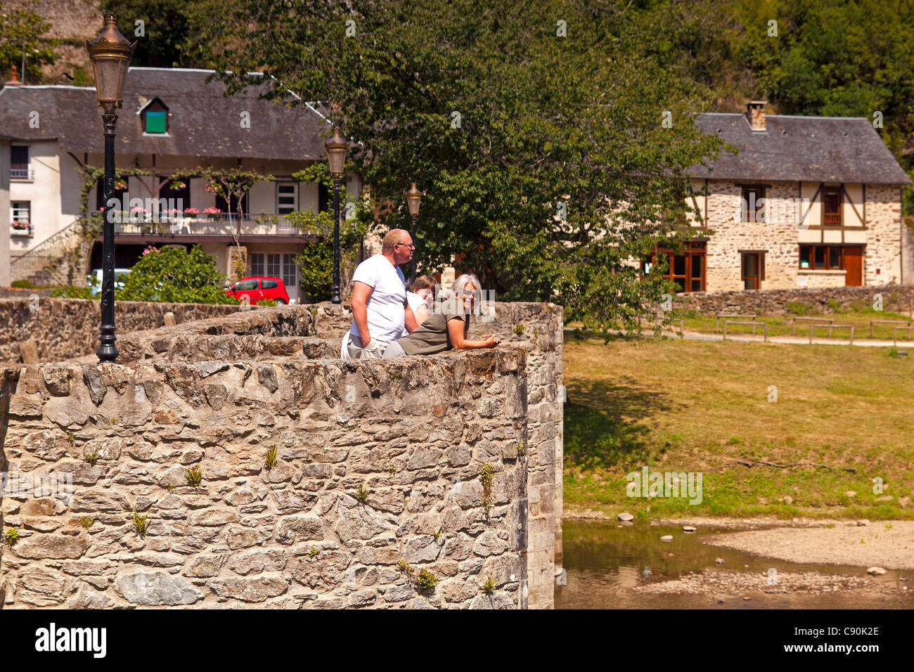 Tre persone in piedi in un molo-testa sul ponte di inglese a Vigeois Foto Stock