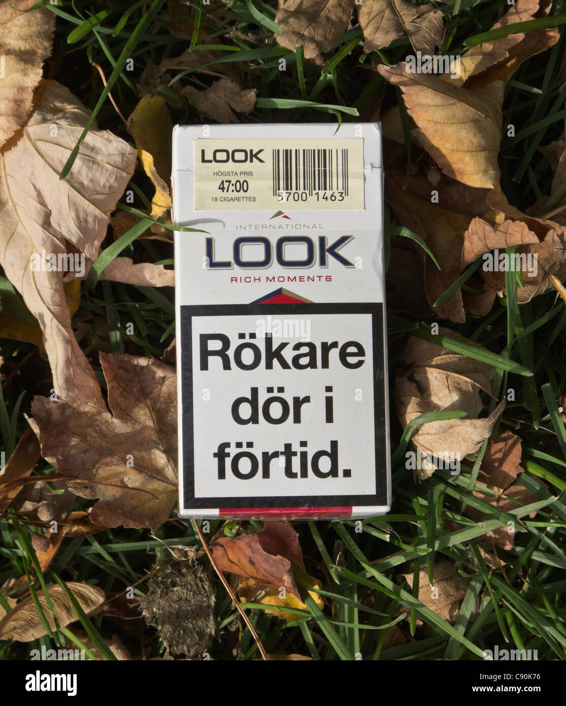 Cercare il pacchetto di sigarette sul terreno. Testo di avviso in lingua svedese afferma "mokers muoiono prematuramente'. Per solo uso editoriale. Foto Stock