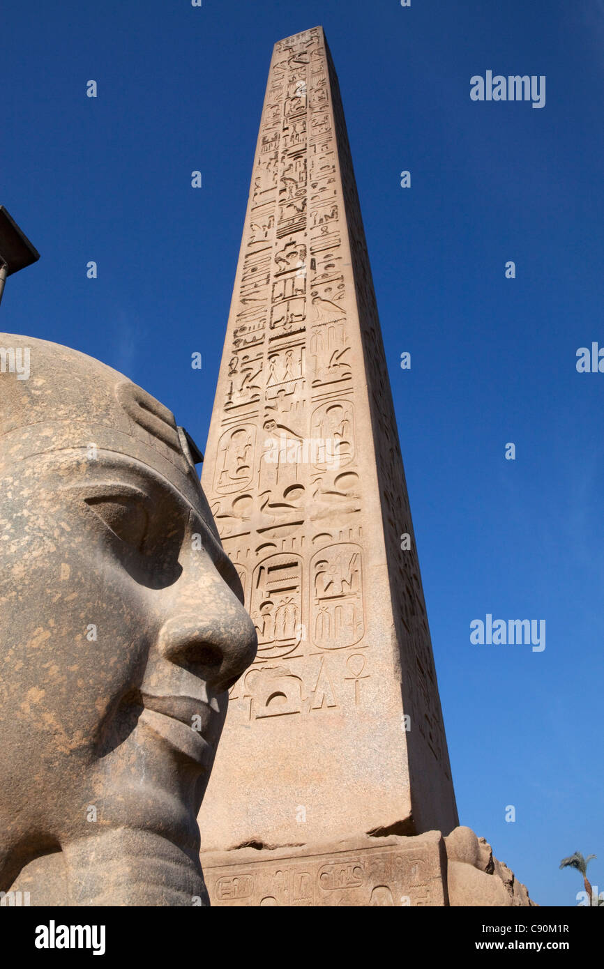 Obelisco e statua colossale di Ramesse II nella zona di ingresso del tempio di Luxor Luxor Egitto, Africa Foto Stock