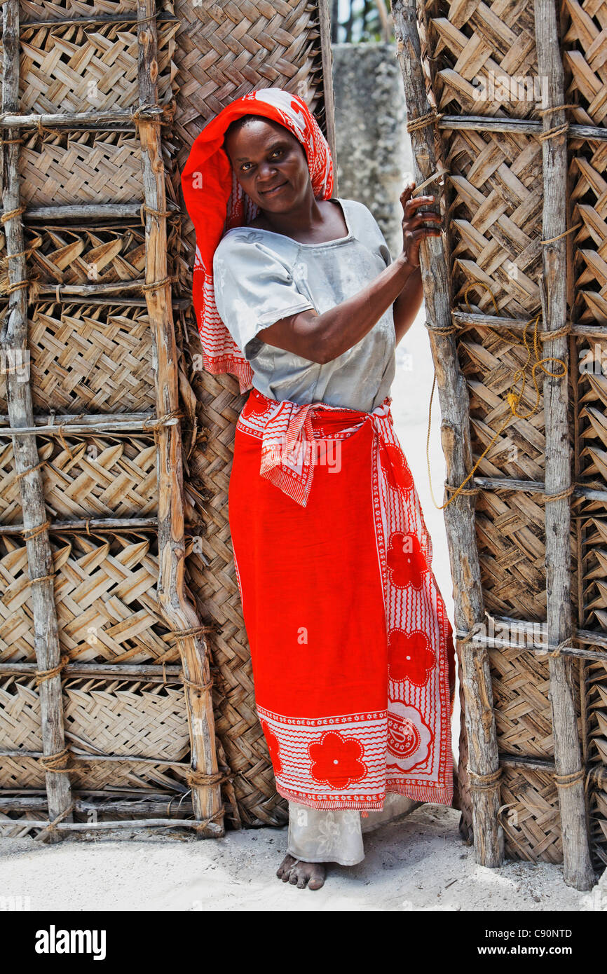 Donna all'entrata al suo Kraal, Jambiani, Zanzibar, Tanzania Africa Foto Stock