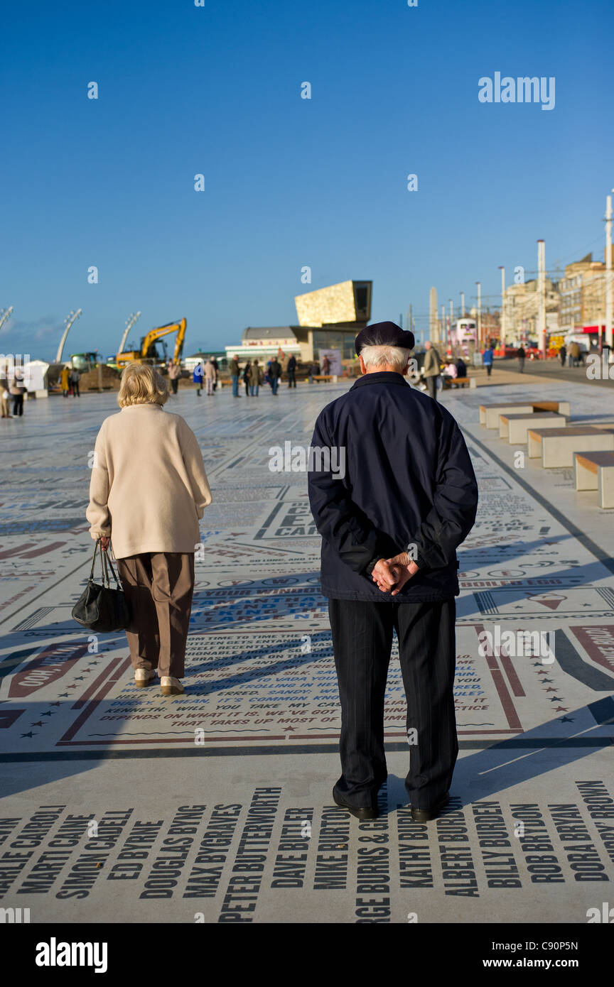 Persone in piedi sulla commedia tappeto sul lungomare di Blackpool Foto Stock