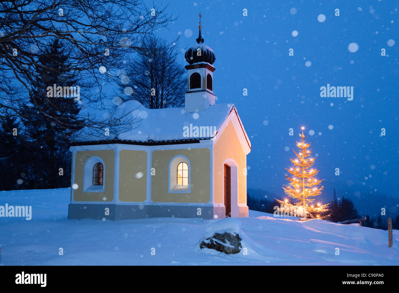 Cappella con albero di natale a nevicata, Alta Baviera, Germania, Europa Foto Stock
