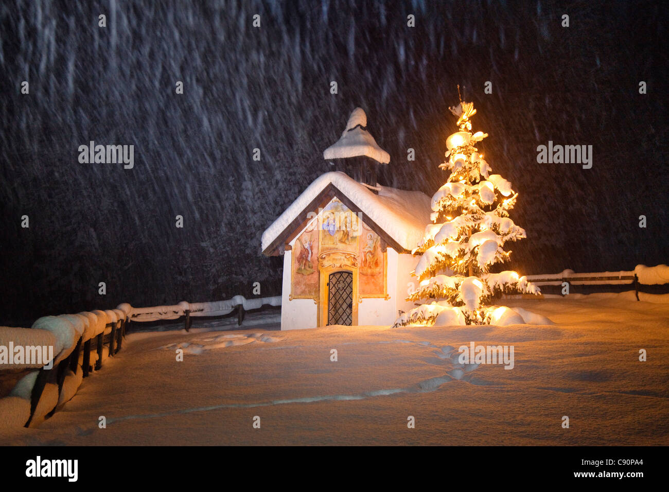 Cappella con albero di natale a nevicata, Elmau, Alta Baviera, Germania, Europa Foto Stock