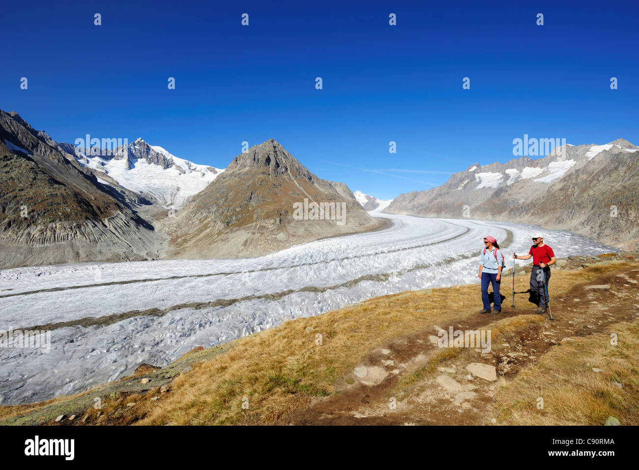Escursionismo coppia sulla via sopra i ghiacciai Grosser Aletschgletscher con Aletschhorn, Grosser Aletschgletscher, patrimonio mondiale dell UNESCO Foto Stock