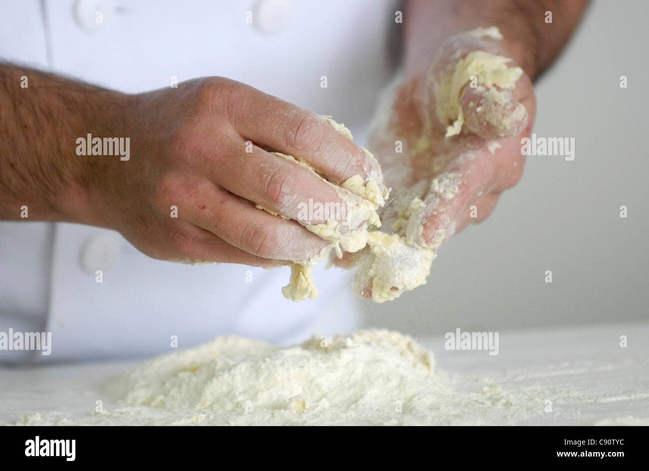 Un baker massaggia di pasta di pane prima della cottura. Foto Stock