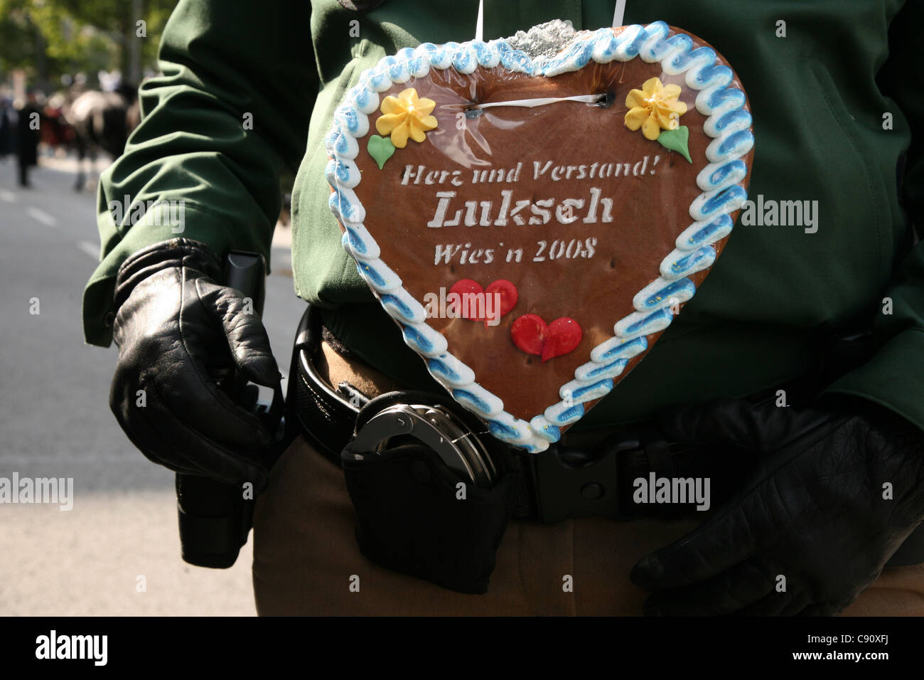 Divisa della polizia decorata con un cuore tradizionale di pan di zenzero al Festival della birra Oktoberfest di Monaco, Germania. Testo in tedesco significa: Cuore e mente Foto Stock