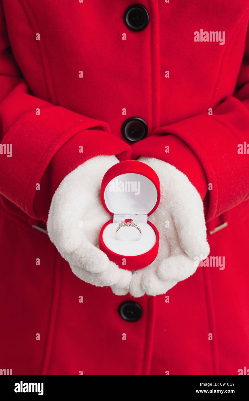 Stati Uniti d'America, Illinois, Metamora, ragazza (10-11) in rosso cappotto azienda anello d'argento nella casella di gioielli Foto Stock