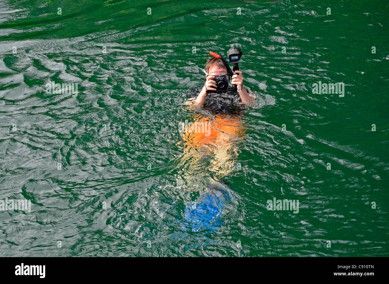 Turistico con fotocamera subacquea, Raja Ampat isole vicino Papua occidentale, in Indonesia nel triangolo di corallo, Oceano Pacifico. Foto Stock