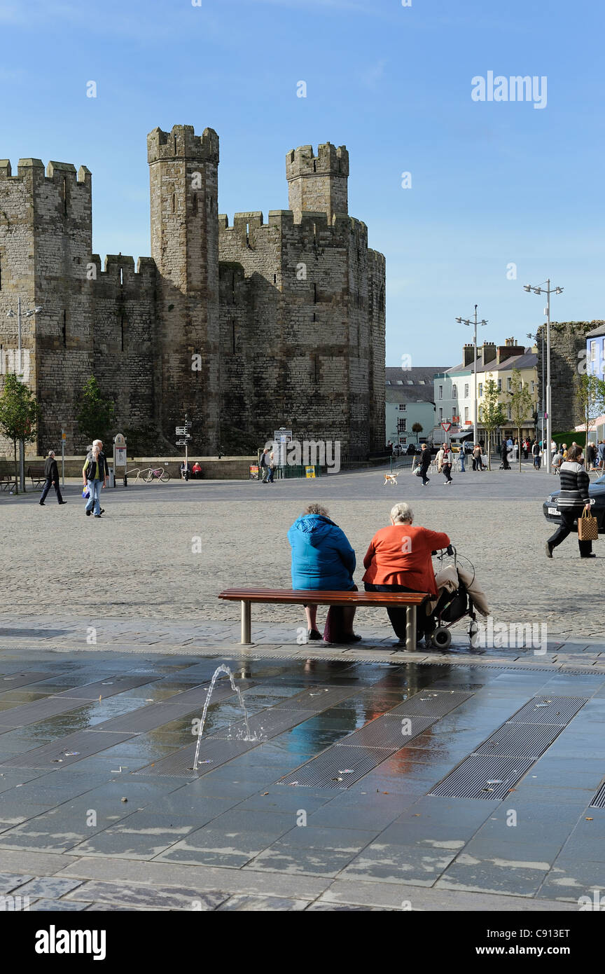 Due anziane signore prendendo in vista in piazza con Caernarfon Castle in background gwynedd north Wales UK Foto Stock