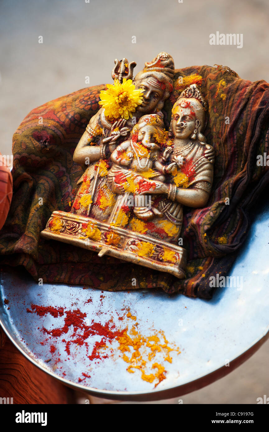 Povero indiano mendicante ragazze piastra con idolo indù. Ganesha, Shiva e Parvati Foto Stock
