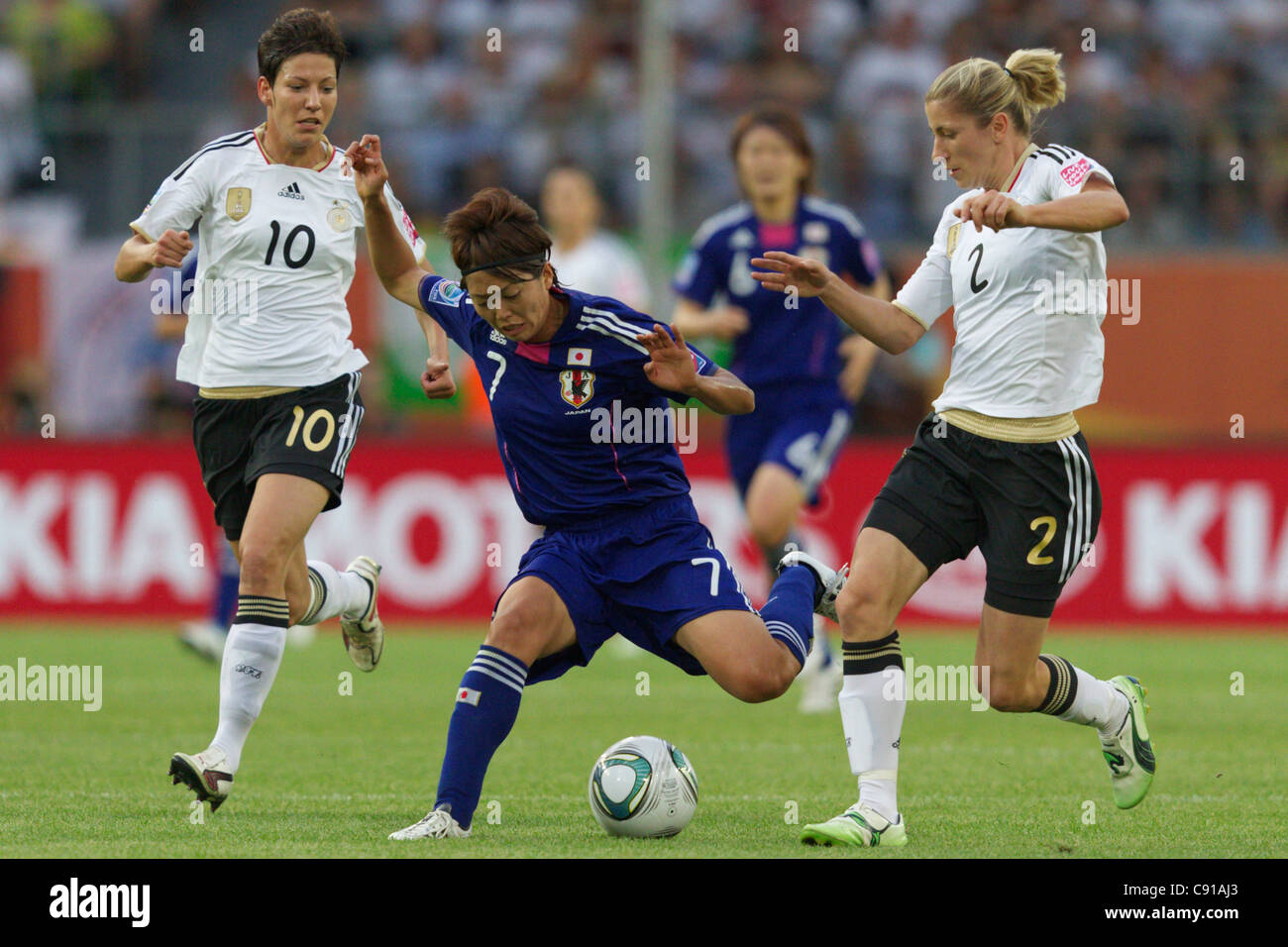 WOLFSBURG, GERMANIA - 9 LUGLIO: Kozue Ando del Giappone (C) combatte per il pallone contro Linda Bresonik (L) e Bianca Schmidt (R) della Germania durante una partita dei quarti di finale della Coppa del mondo femminile all'Arena Im Allerpark il 9 luglio 2011 a Wolfsburg, Germania. Solo per uso editoriale. Uso commerciale vietato. (Fotografia di Jonathan Paul Larsen / Diadem Images) Foto Stock