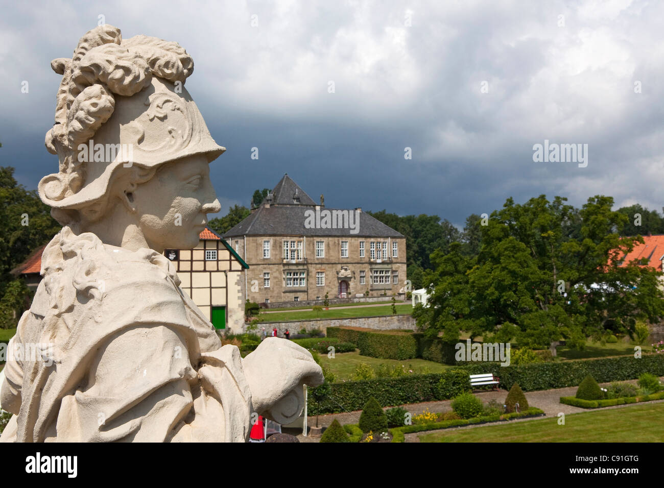 Gesmold castello e castello, scultura in primo piano, nuvole nere, Gesmold, Meller, Bassa Sassonia, Germania Foto Stock