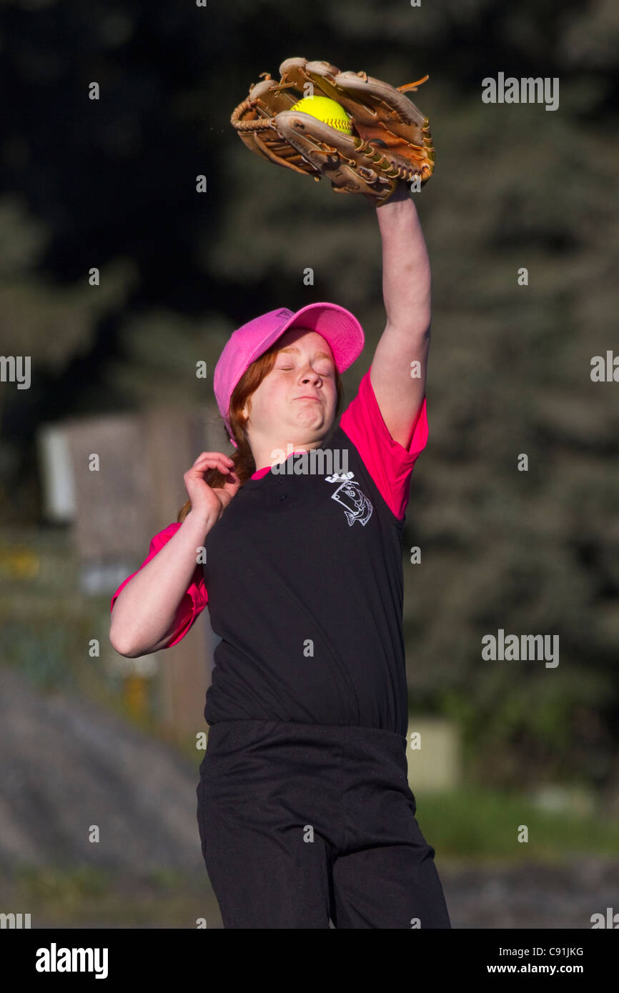 Ragazza giovane la cattura di softball con gli occhi chiusi, Cordova little League, Cordova, centromeridionale Alaska, estate Foto Stock