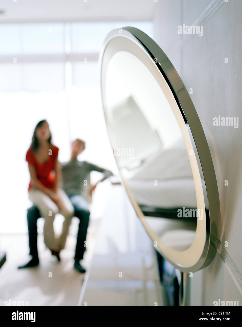 Giovane donna sat su fidanzati ginocchia Hotel camera al secondo piano progettato da Norman Foster Hotel Silken Puerta America Madrid Spa Foto Stock