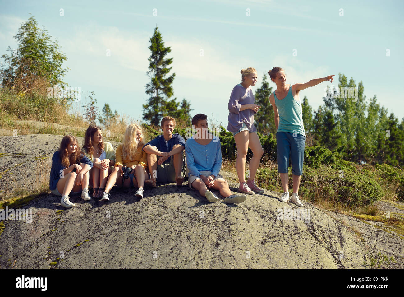 Amici seduti insieme sul boulder Foto Stock
