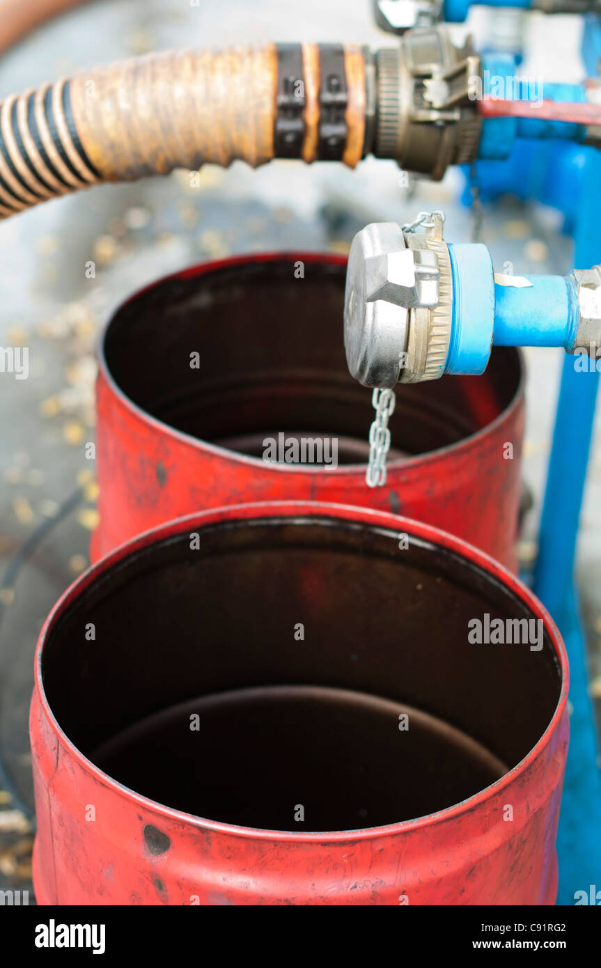 Grande carrello tubi flessibili per stazione di carburante, pompe e barili di olio Foto Stock