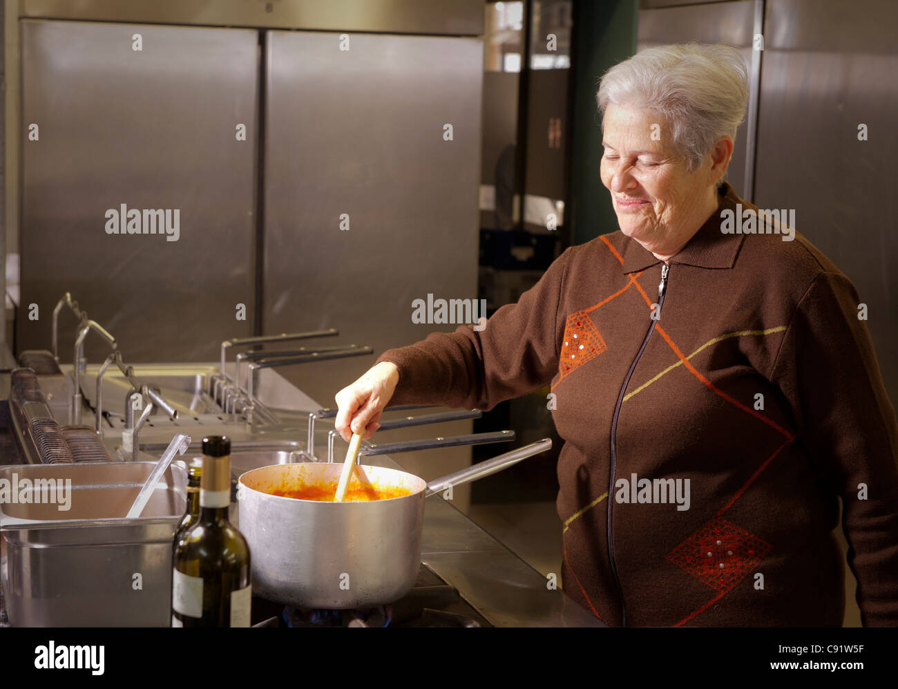 Donna italiana agitazione in salsa di stufa Foto Stock