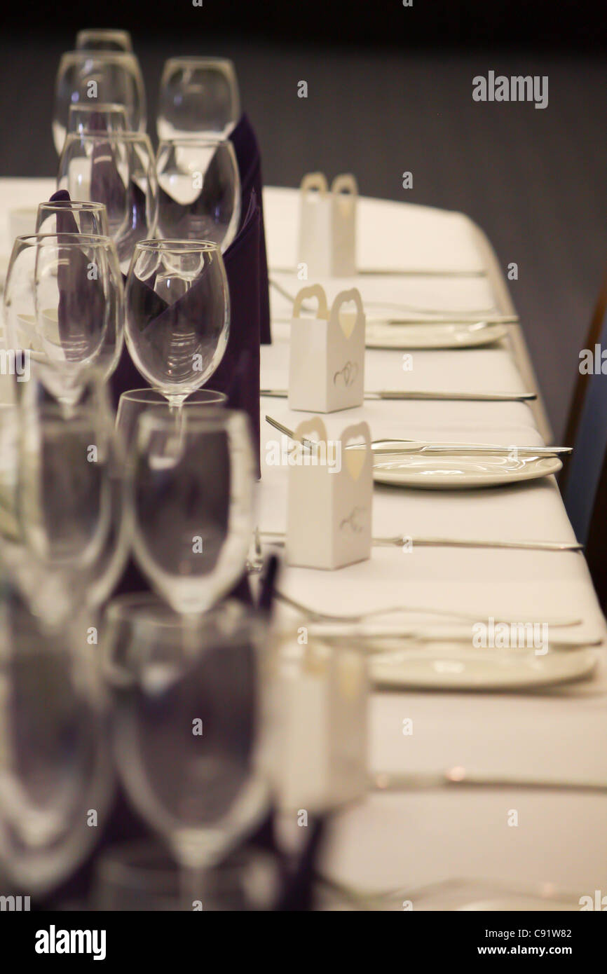 La sposa e lo Sposo le regolazioni del posto e i loro ospiti a capo tavola superiore il giorno delle nozze, tutti i vuoti, impostato e pronto. Foto Stock