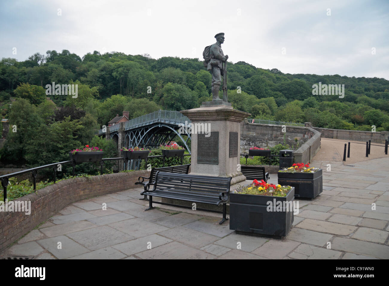 Monumento ai caduti in guerra con lo storico ponte di ferro dietro il primo del suo genere costruito nel 1779, in Ironbridge Gorge, Shropshire, Regno Unito. Foto Stock