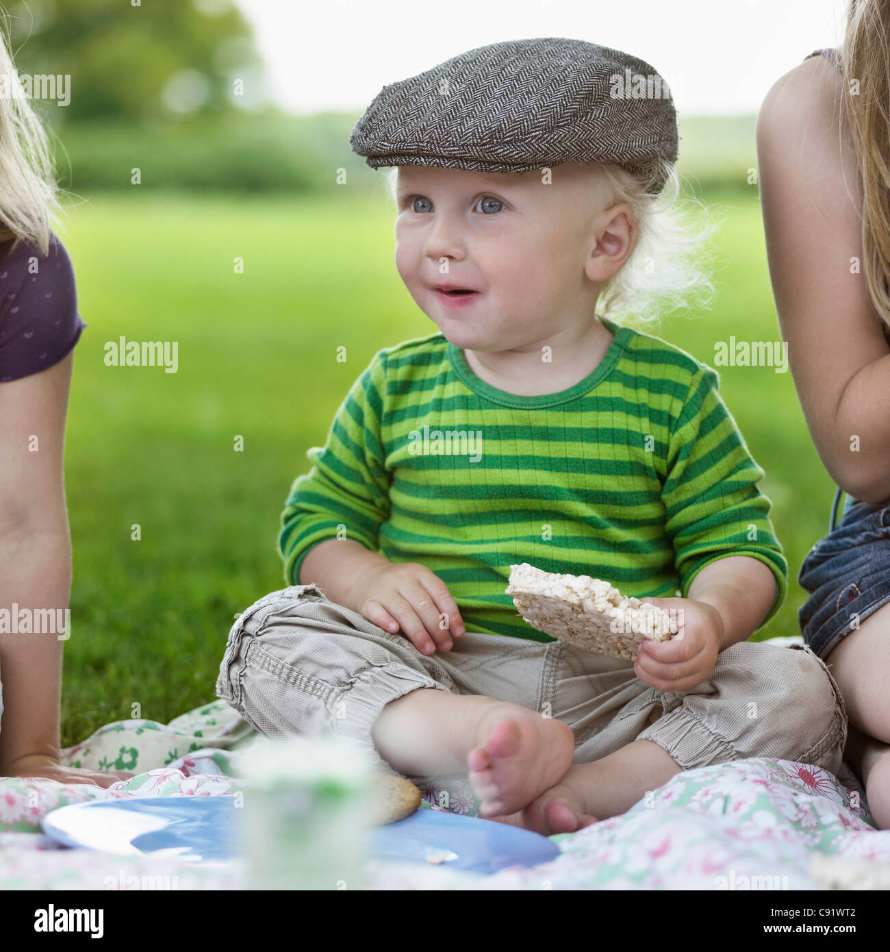 Ragazzo di mangiare la torta di riso al picnic Foto Stock