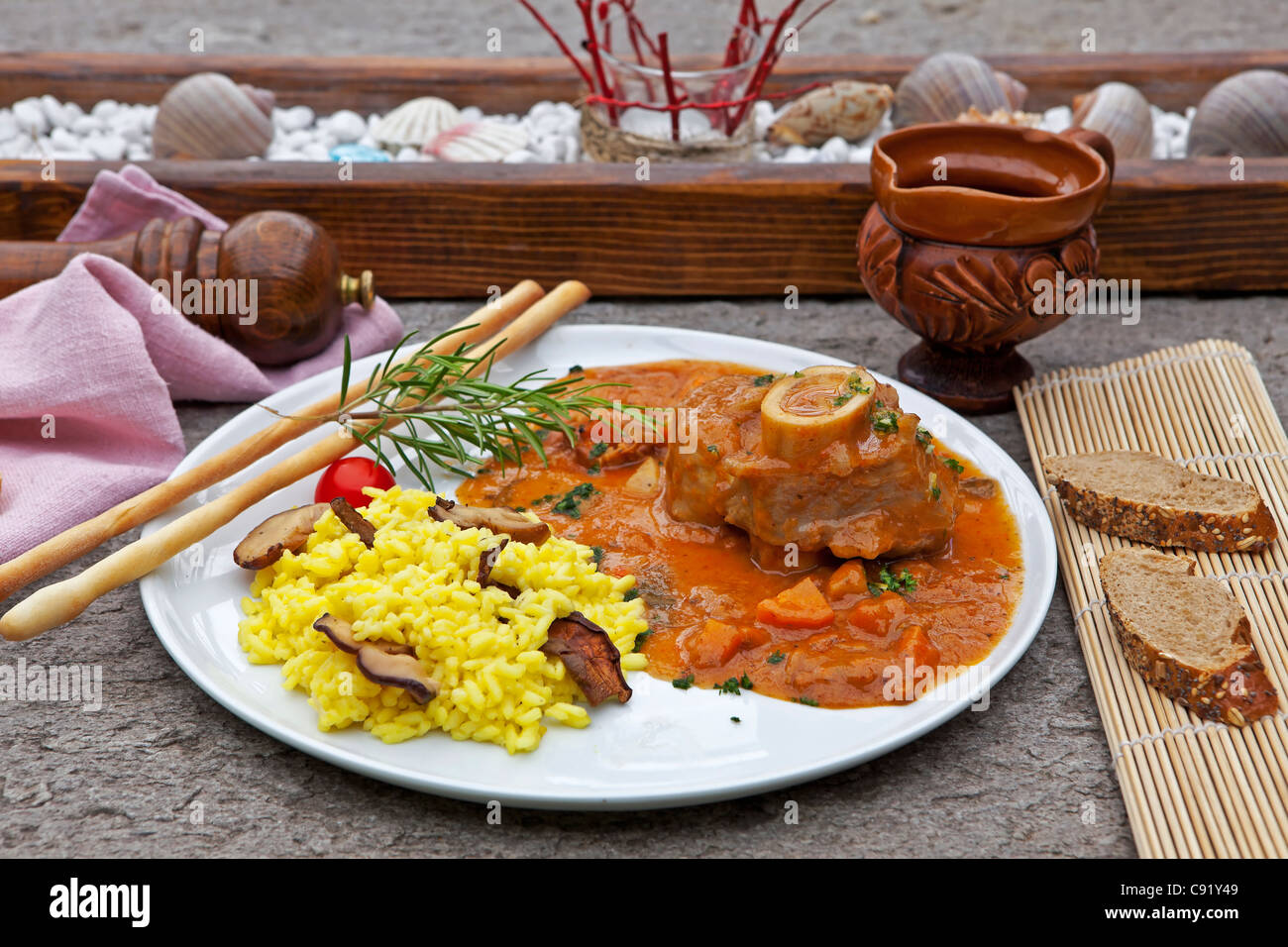 Ossobuco con funghi porcini risotto, servita sulla terrazza di una grotta in Ticino Foto Stock
