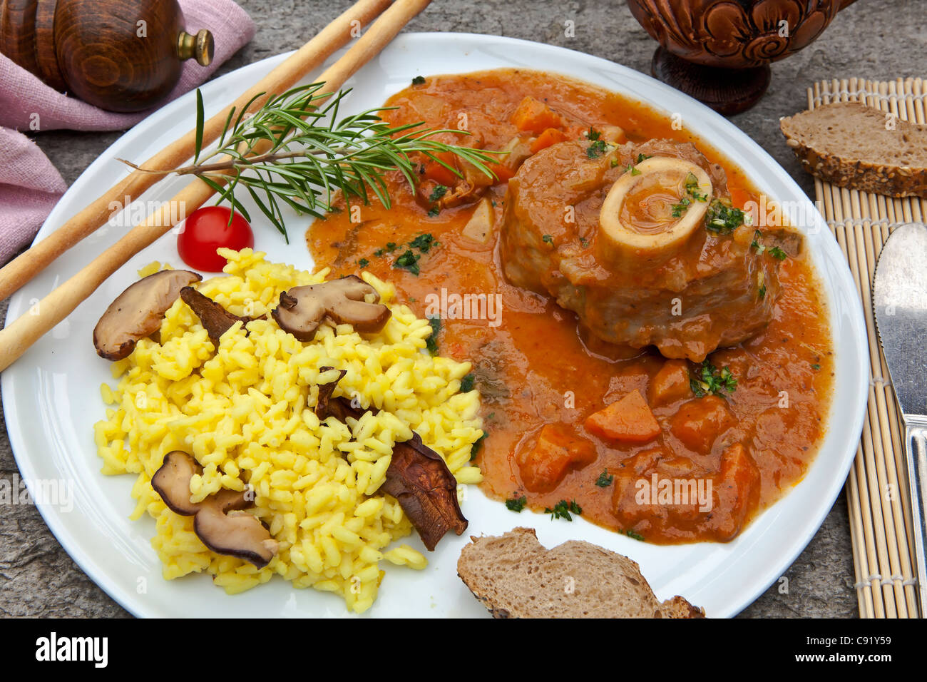 Ossobuco con funghi porcini risotto, servita sulla terrazza di una grotta in Ticino Foto Stock