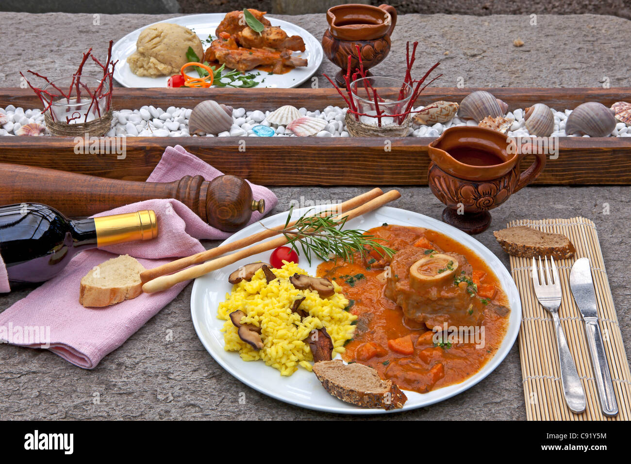 Ossobuco con funghi porcini risotto, servita sulla terrazza di una grotta in Ticino Foto Stock